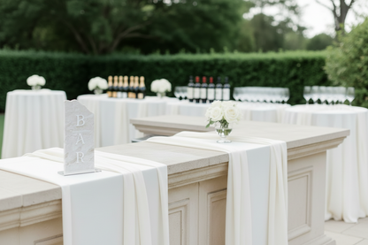 Elegant outdoor dining setup with white tablecloths and floral centerpieces.